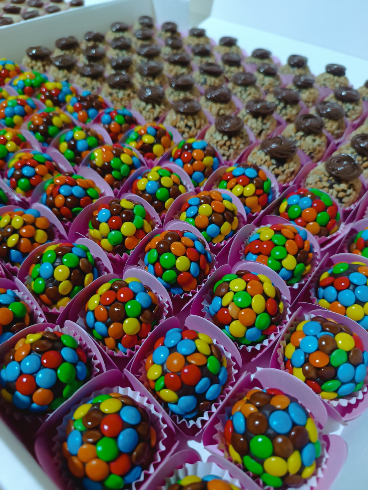 Brigadeiros de chocolate cobertos com confeitos coloridos